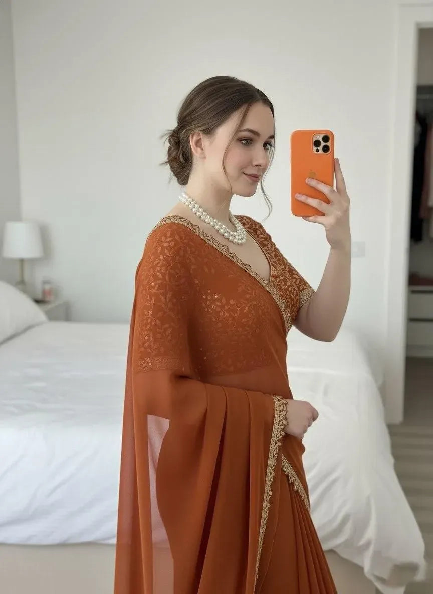 Close-up of model wearing rust orange silk saree taking mirror selfie