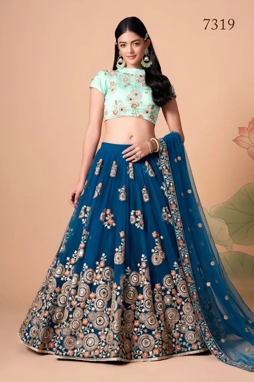 Model wearing teal blue net mirror work lehenga front view