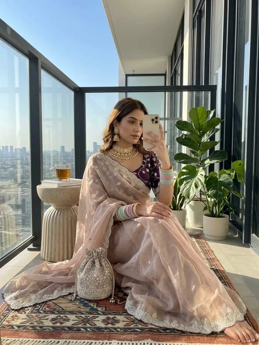 Woman wearing peach tissue silk saree with heavy work on balcony