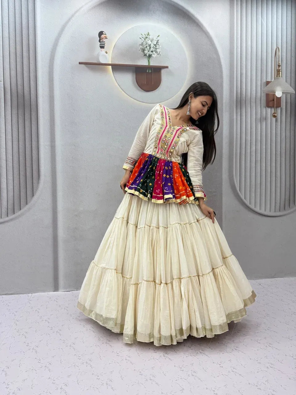Model wearing off-white traditional kediyu lehenga with mirror work