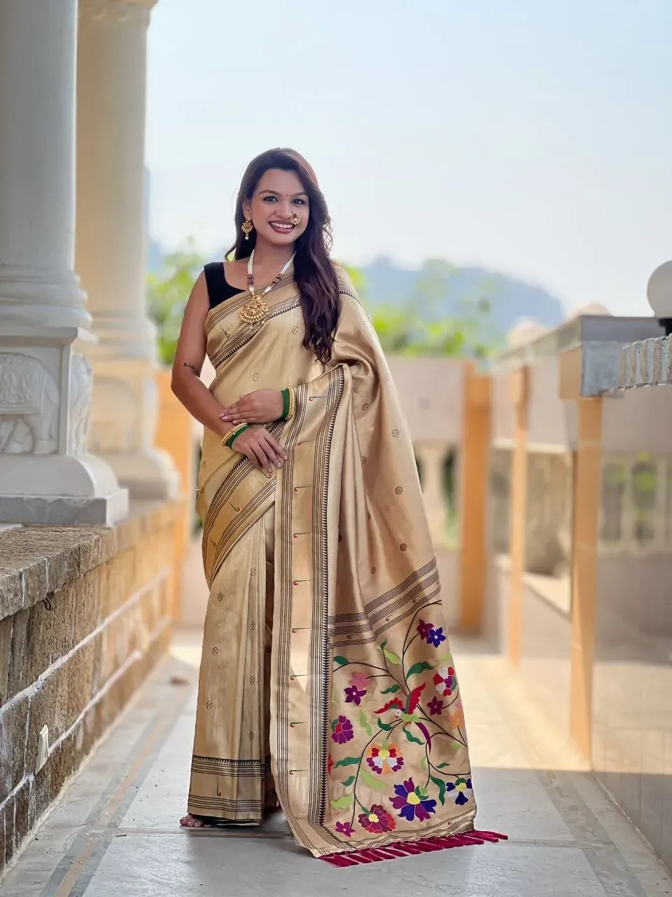 Woman posing gracefully in golden zari paithani silk saree outdoors