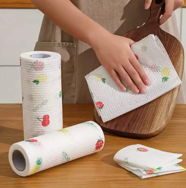 Floral-patterned paper towels on a wooden table with a person using them.