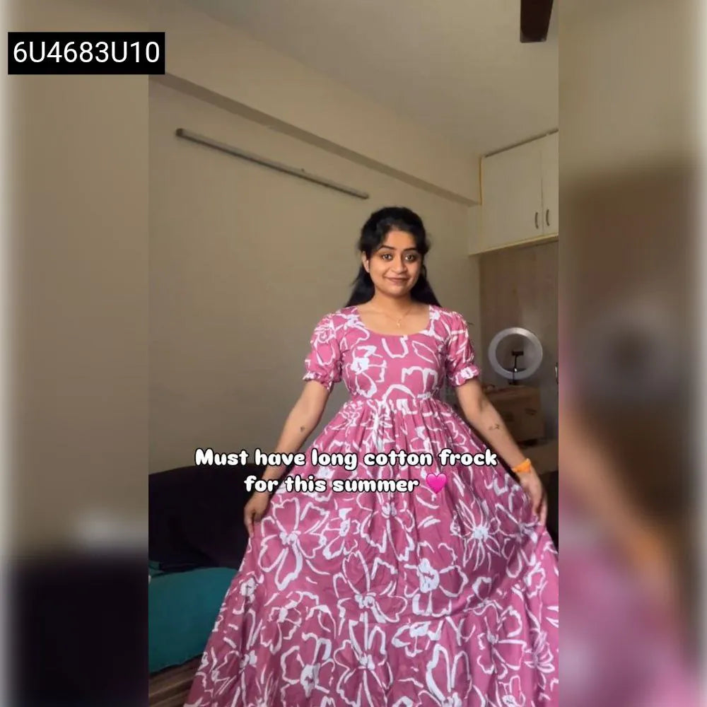 Young woman wearing the pink floral print cotton maxi dress, full body shot, standing indoors.