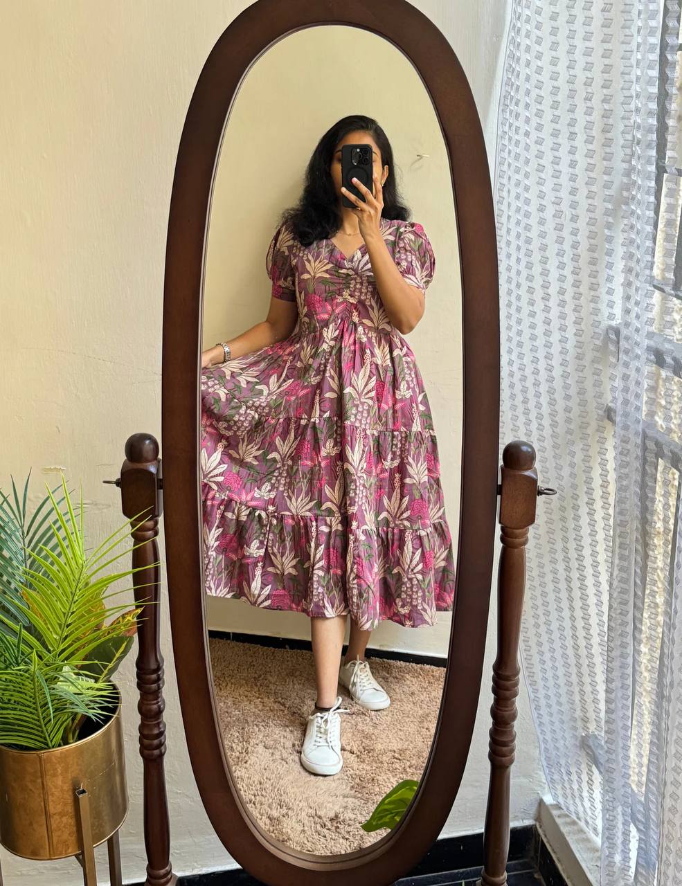 Woman in lavender floral tiered maxi dress with ruched V-neck, reflecting in a mirror, full length view.