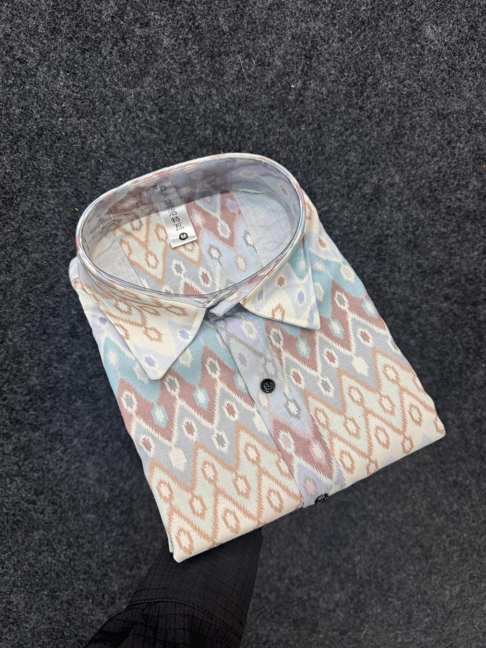 Folded men's cotton linen shirt with intricate geometric pattern on dark background, showcasing its unique design.