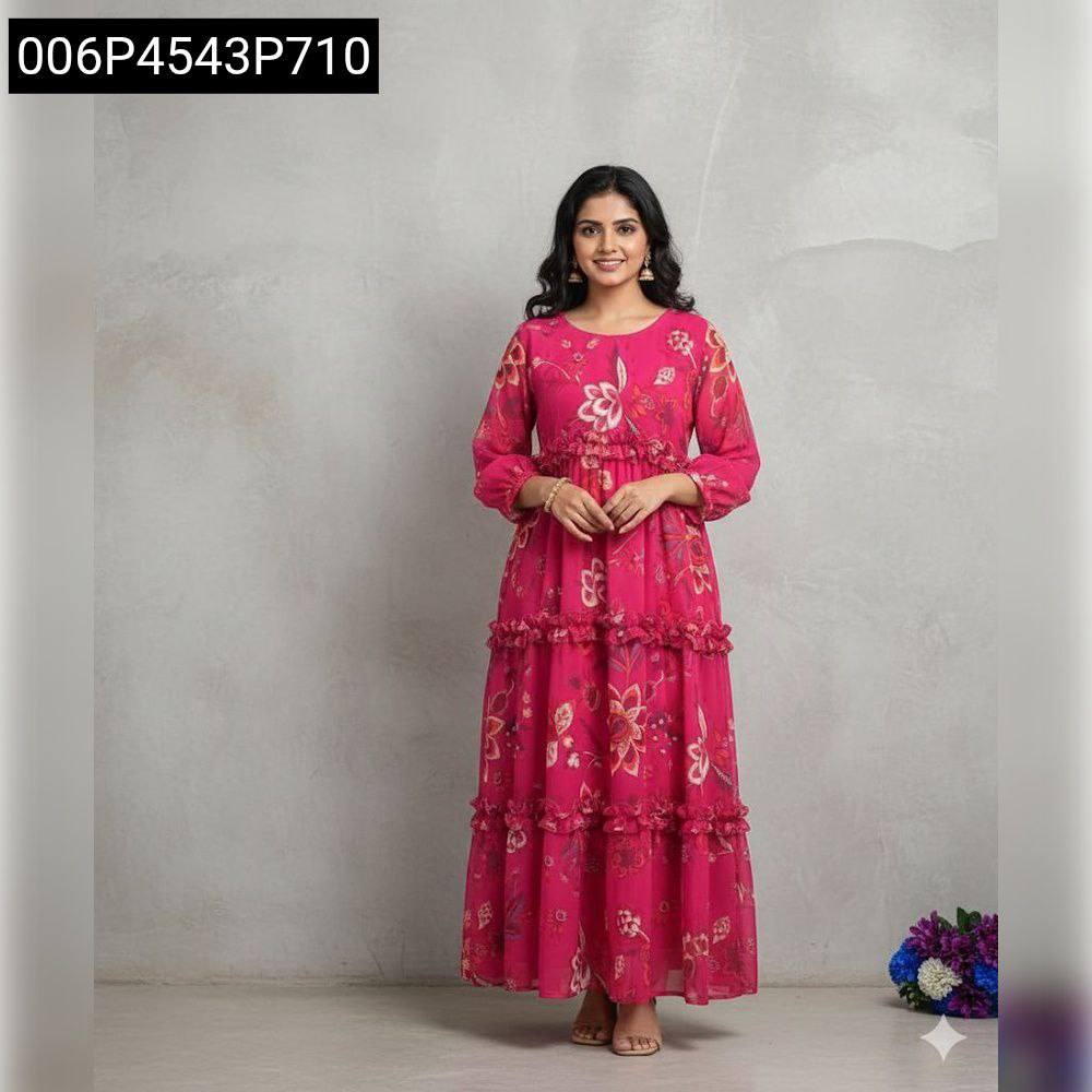 Woman smiling in a hot pink tiered floral short-sleeve Georgette maxi dress, standing against a grey wall.
