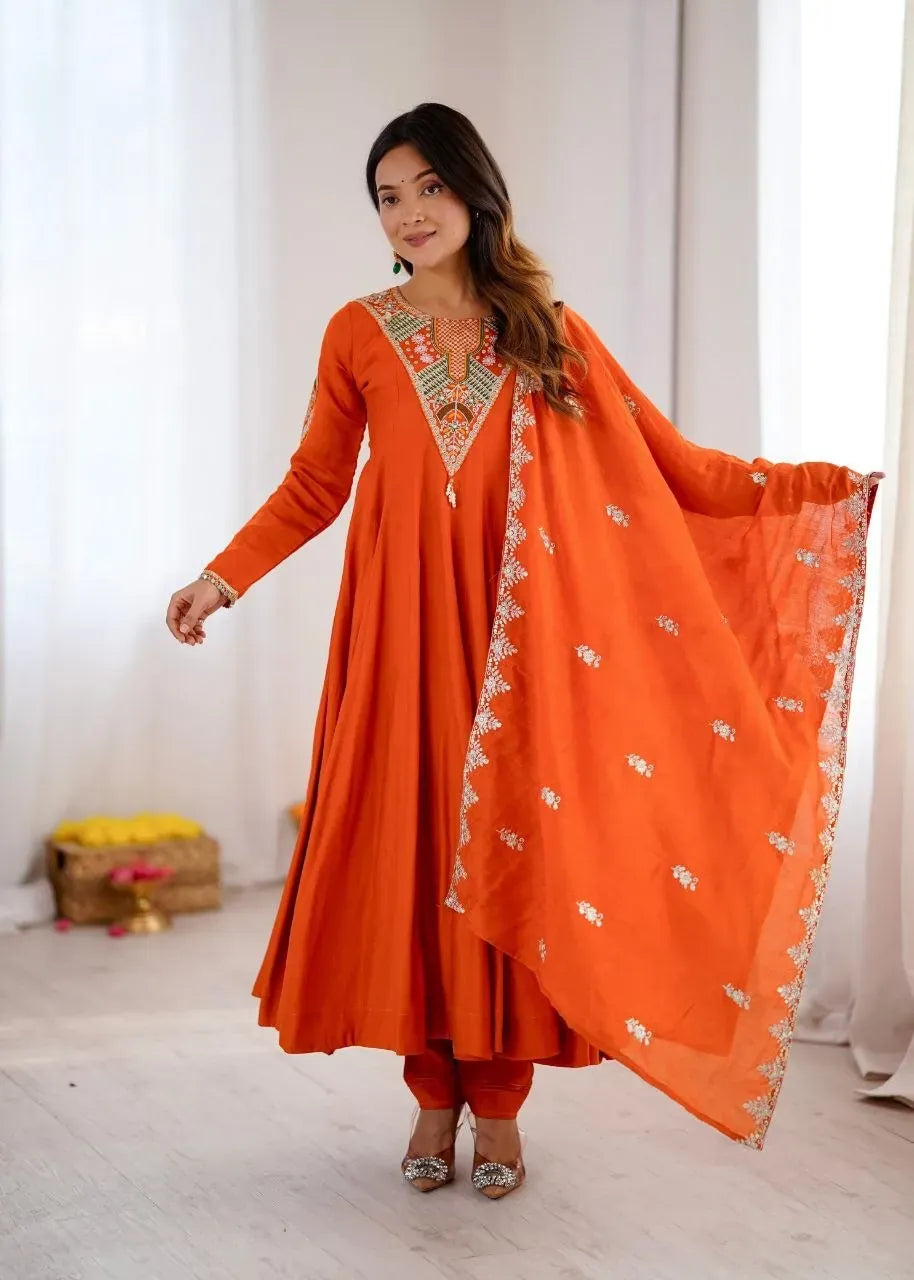 Model wearing orange designer anarkali gown with dupatta and bottom