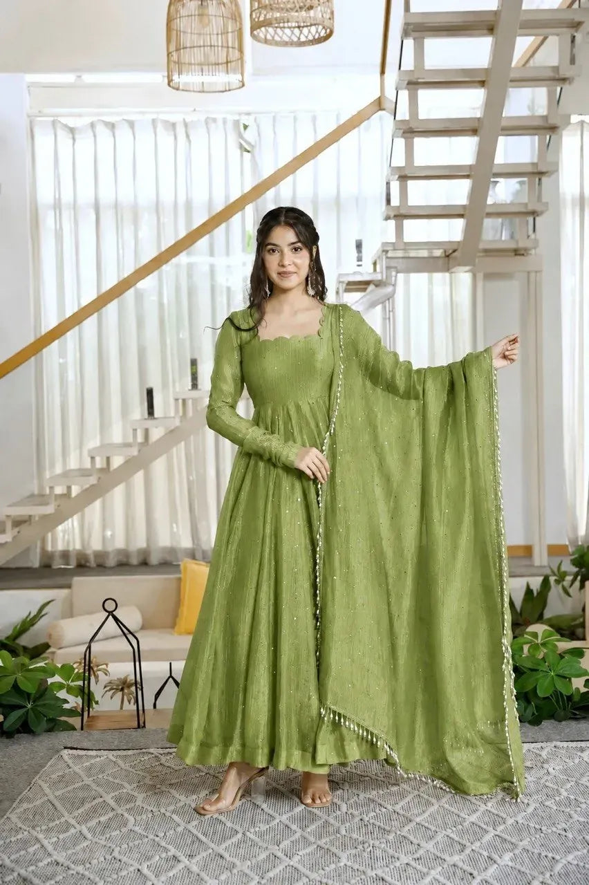 Model wearing green salsa silk gown with foil work holding dupatta