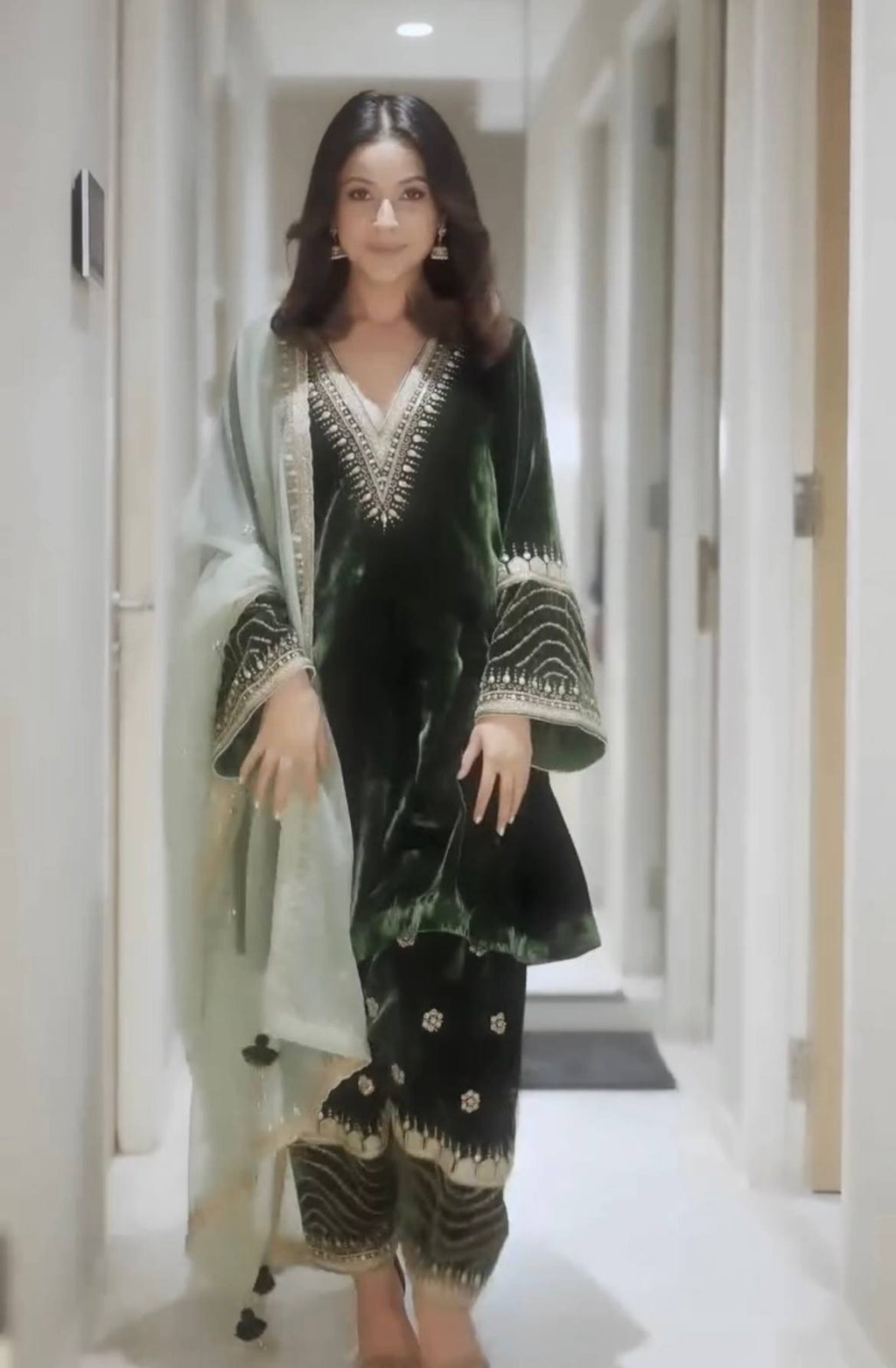 Model wearing green embroidered velvet silk kurti pant set with light green dupatta, full body shot