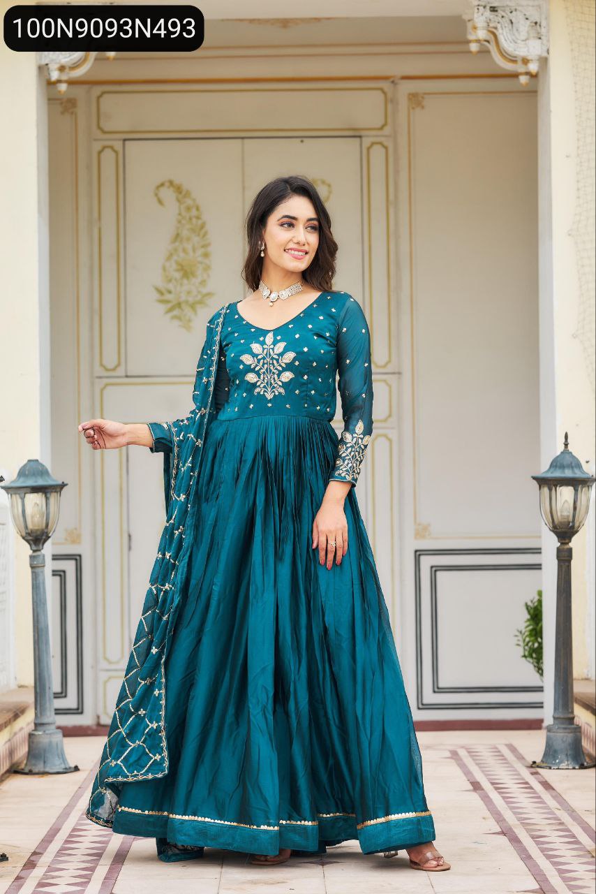 Woman posing in a teal heavy sequence embroidered Rangoli gown with dupatta.