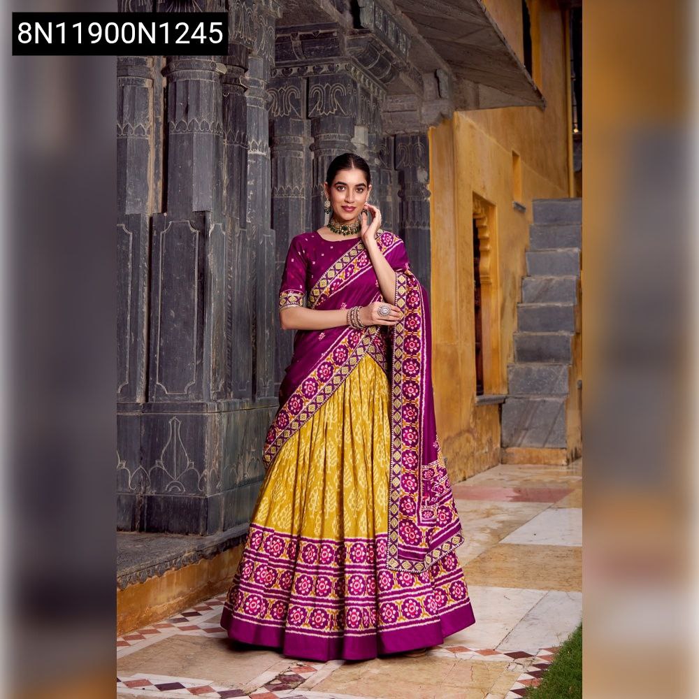 A woman posing in a Mustard Yellow and Regal Purple Ikkat Print Tasar Silk Lehenga Choli, front-facing.