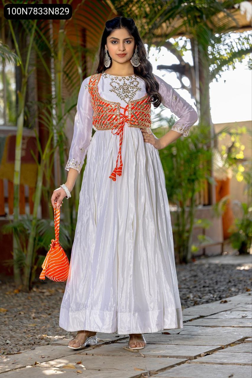 Front full body view of the model confidently posing in the Indo-Western gown with attached jacket and hand purse, outdoors.
