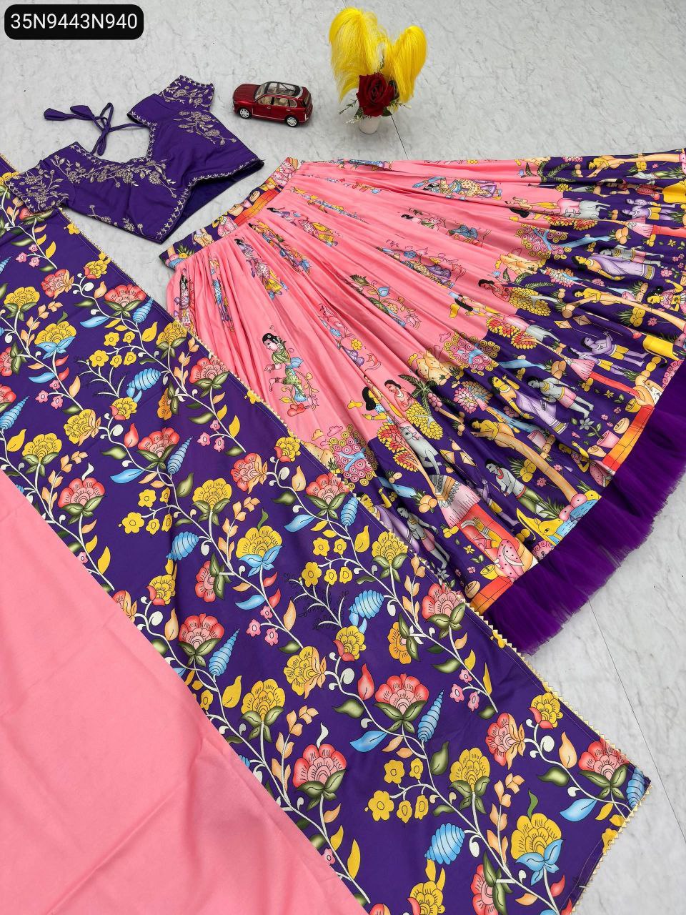 Flat lay of Kalamkari print cotton lehenga choli set with pink lehenga and purple blouse/dupatta