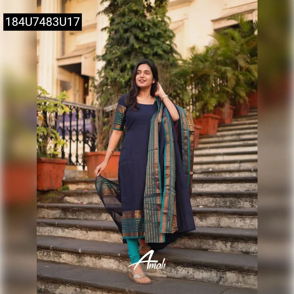 Full shot of a woman in a navy Kanchi cotton suit set with teal leggings and a matching dupatta, standing on outdoor stairs.
