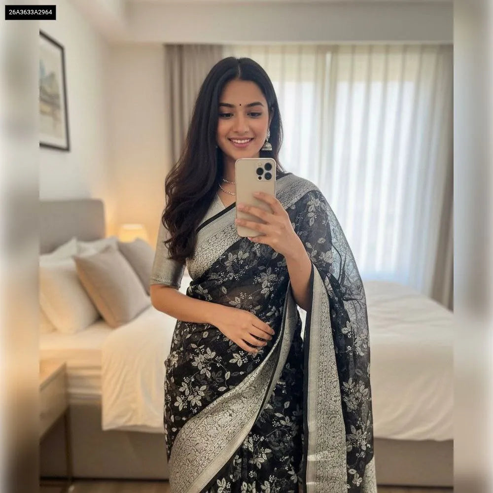Model wearing a Jet Black Kanchipuram Organza Saree with jacquard and foil work, silver border, and a matching blouse, front facing.