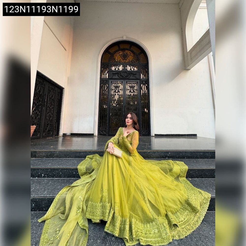 Woman in lime green Kediya style shrug lehenga, sitting elegantly on steps, front view.