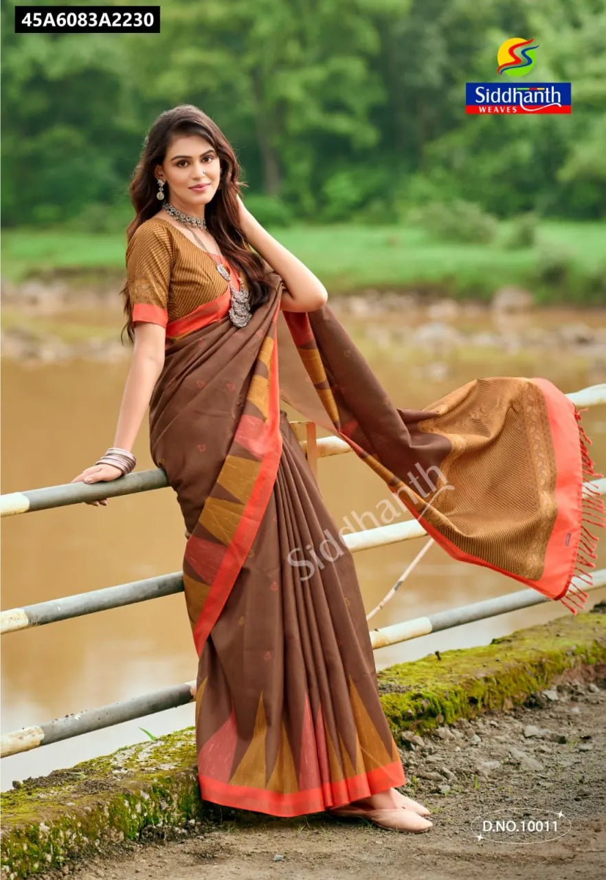 Elegant woman in a brown Kota Lilen Banarasi saree with digital print and bentex border, posing by a river.