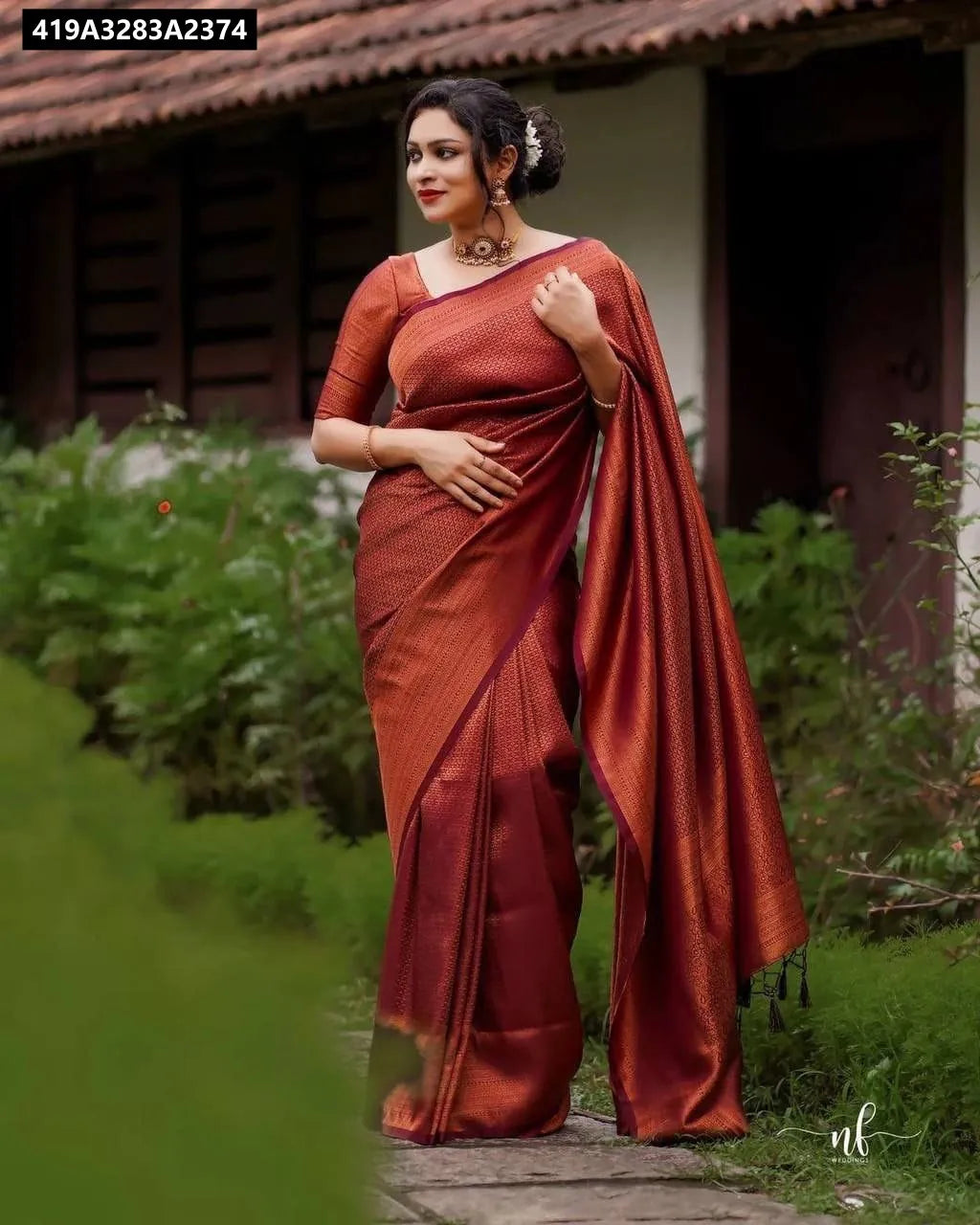 Full shot of model in maroon Lichi Silk Jacquard Saree, elegant drape against a garden backdrop