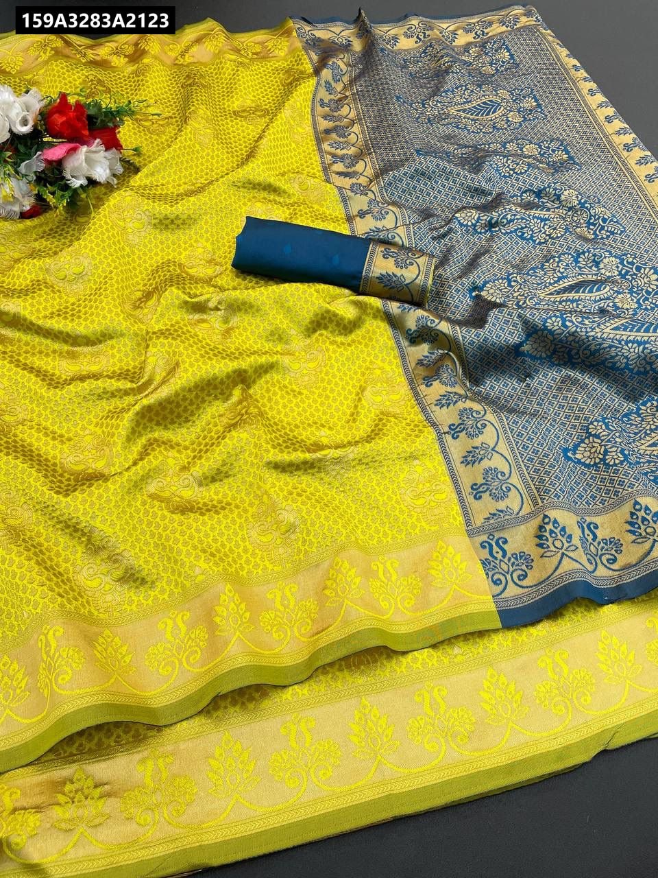 TRENDBUY Lichi Silk Saree in Mustard Yellow with contrasting blue pallu and woven zari motifs, flat lay.