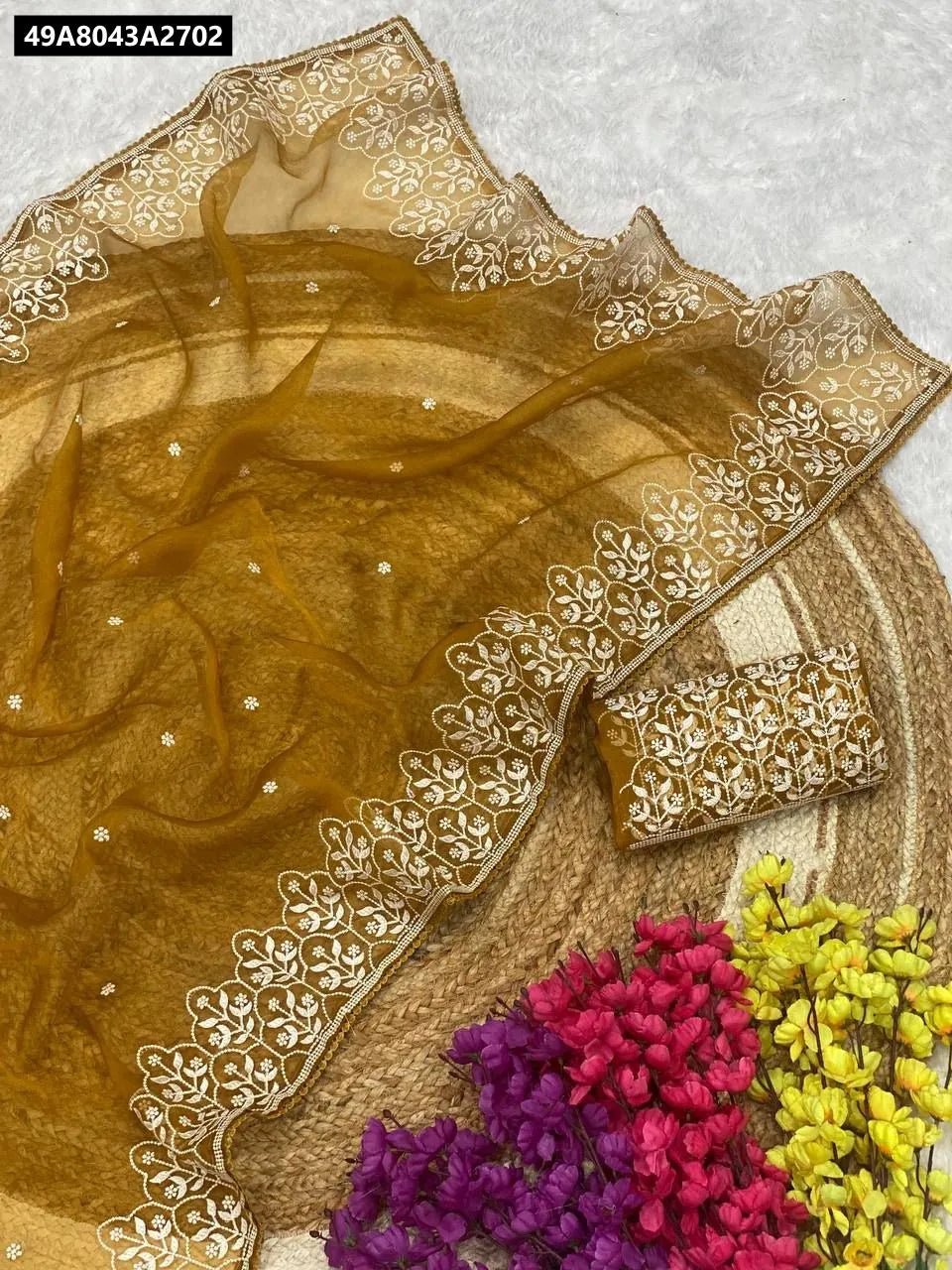 TRENDBUY Lightweight Embroidered Organza Saree in Golden Brown with white embroidery and lace, flat lay with flowers.