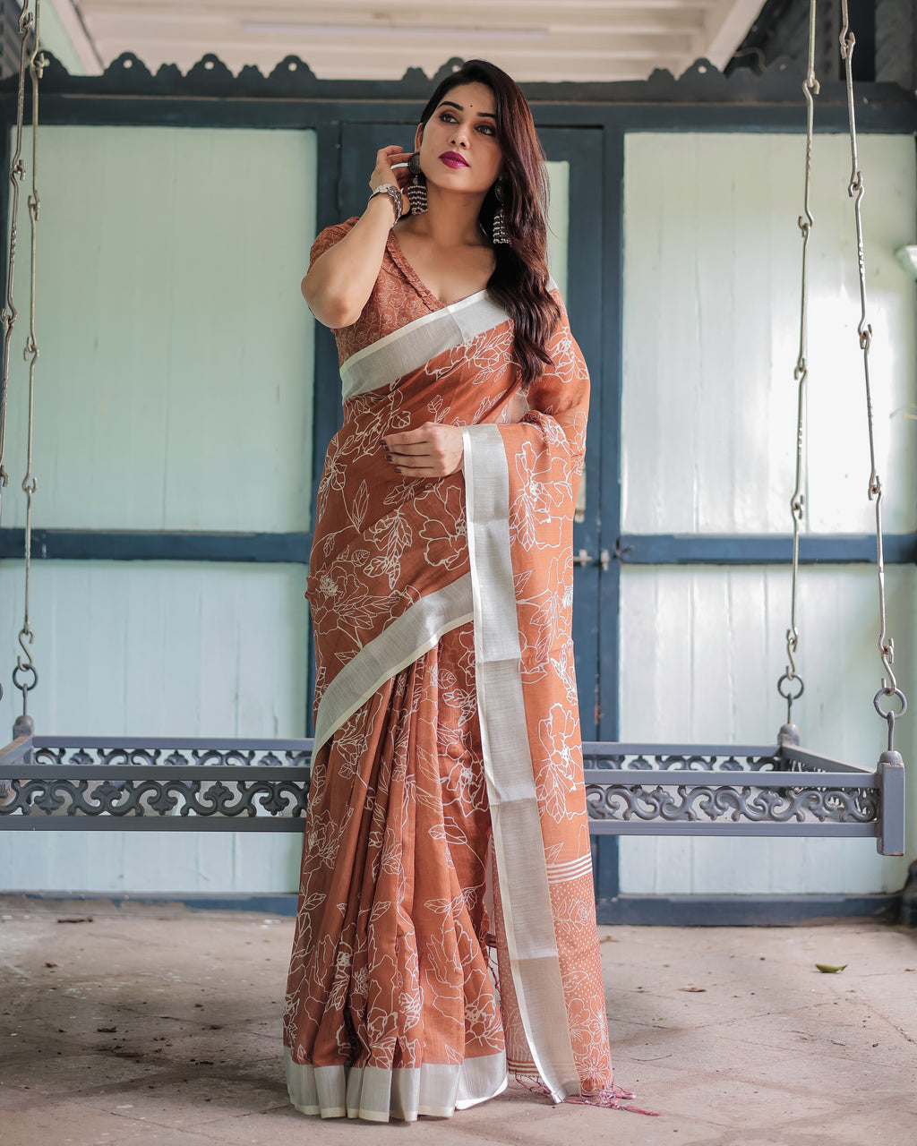 Women's EARTHY Linen Saree in terracotta brown with white floral print and silver border, full body shot