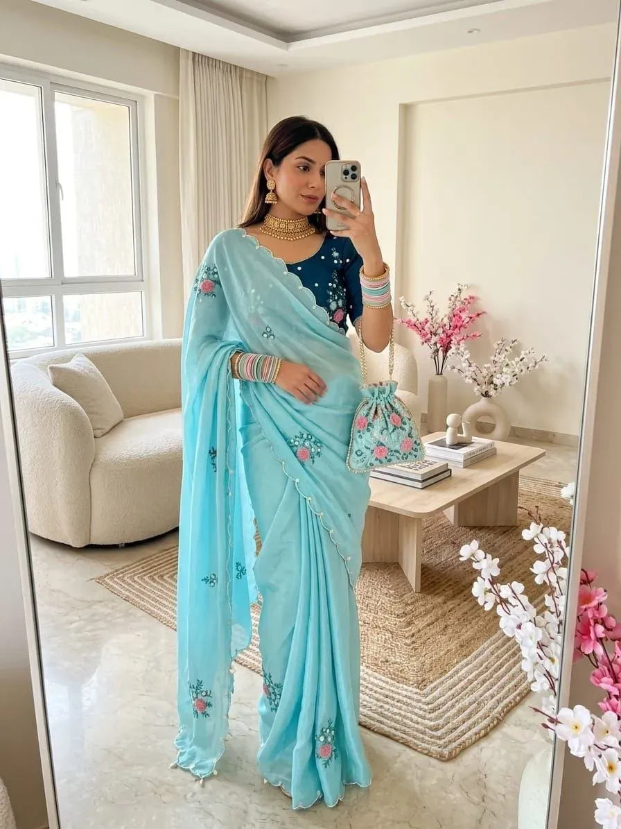 Model wearing sky blue chinnon saree holding embroidered potli bag
