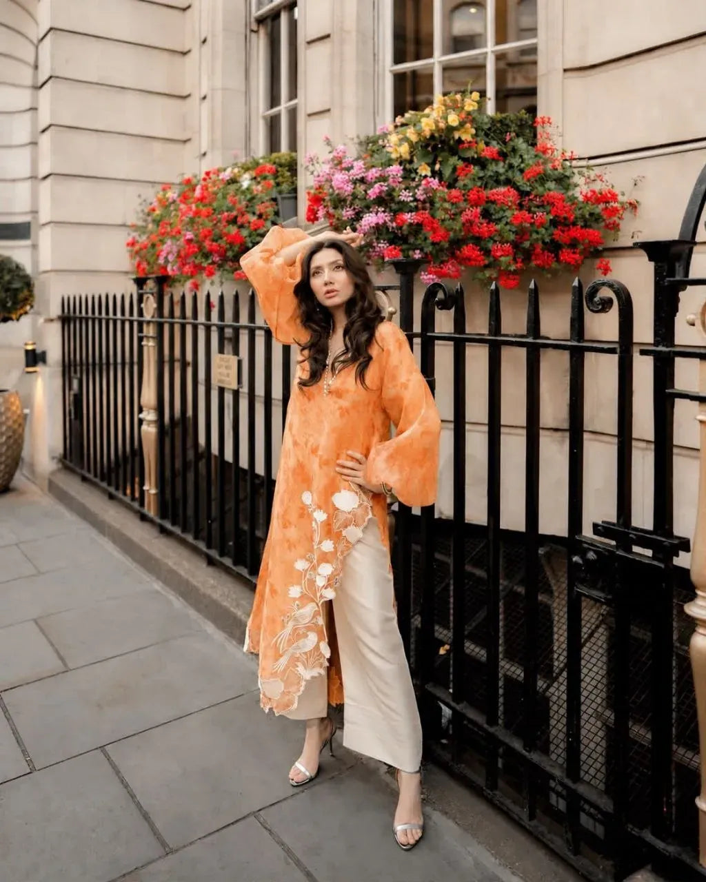 Full body shot of model in orange organza 3-piece set with balloon sleeves