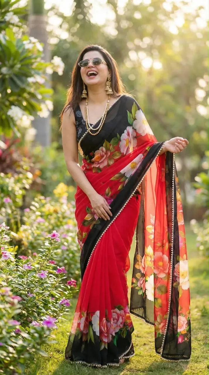 Model standing outdoors showcasing the front drape of a black georgette saree adorned with red and pink floral prints