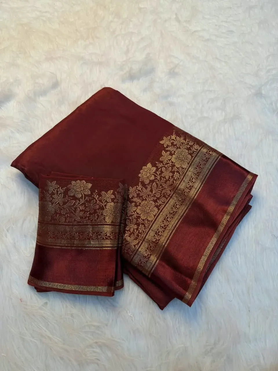 Folded maroon pure viscose saree with matching embroidered blouse piece on white background