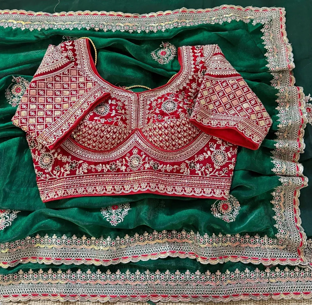 Green space silk saree draped with red heavy embroidered blouse