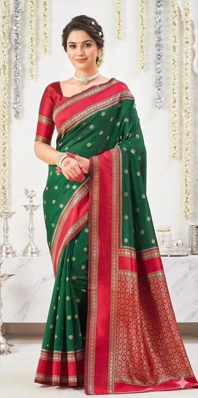 Model standing in traditional green and red silk saree with rich pallu