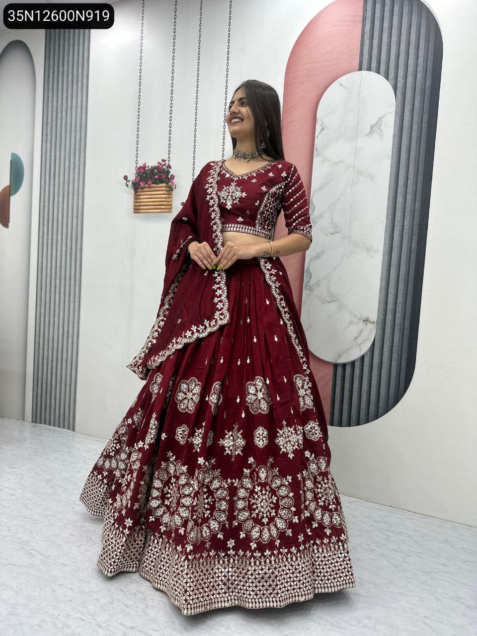 Elegant model presenting the full maroon heavy embroidered Vichitra silk lehenga set.