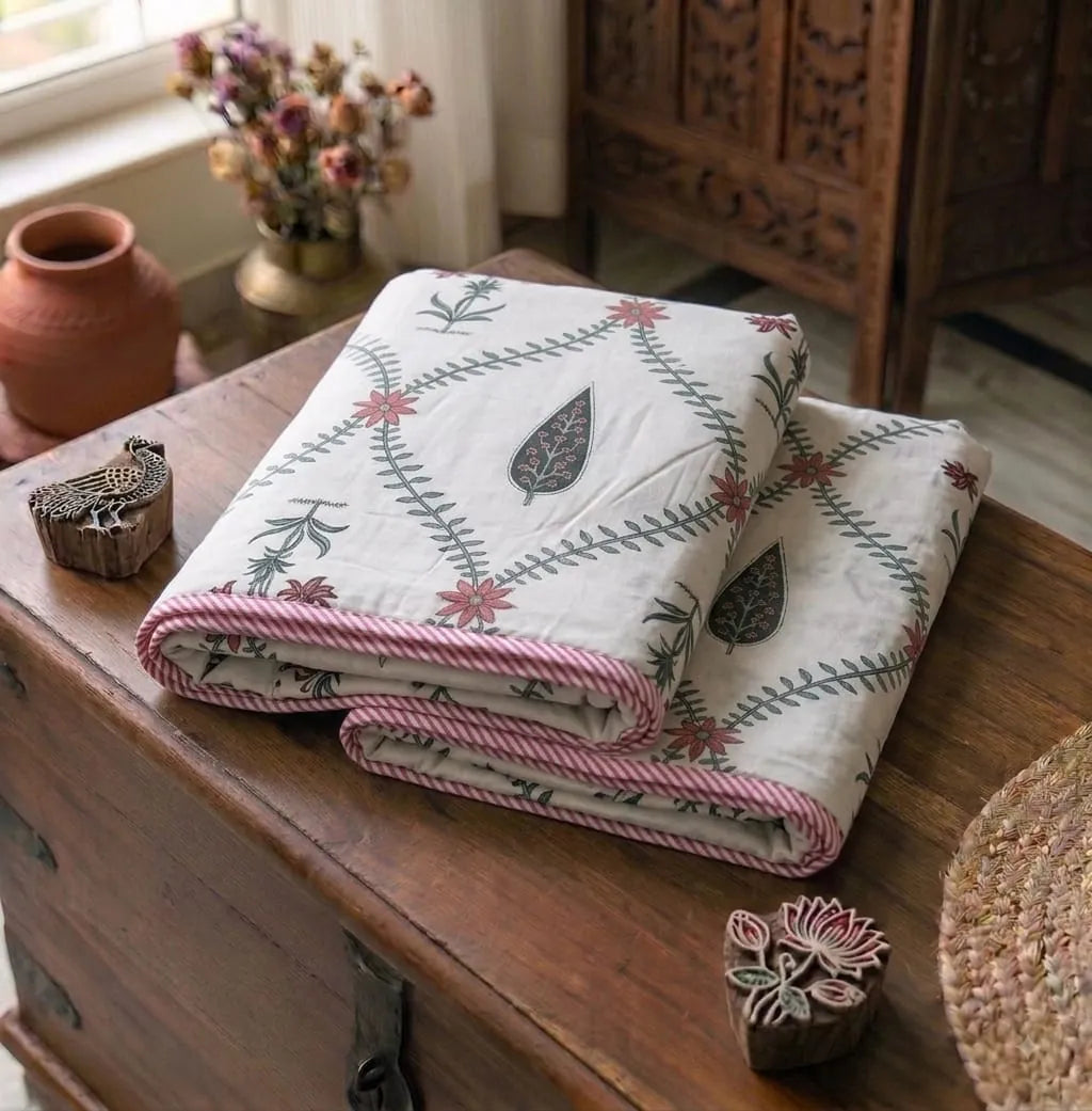 Red floral print mix cotton reversible single bed dohar folded on wooden chest