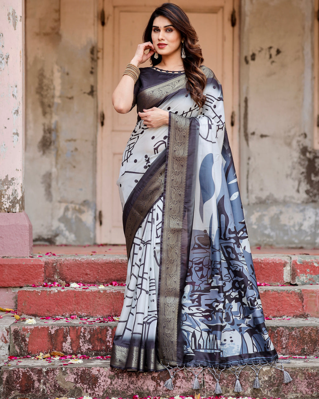 Woman in full shot wearing a monochrome abstract print silk saree with gold zari border, suitable for evening wear.