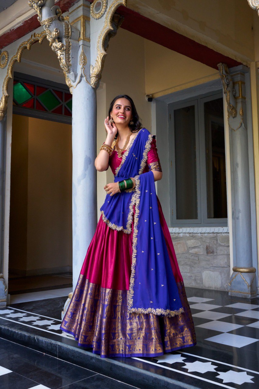 Model posing in a vibrant fuchsia pink and royal blue Narayan Pattu Lehenga Choli with intricate zari work.