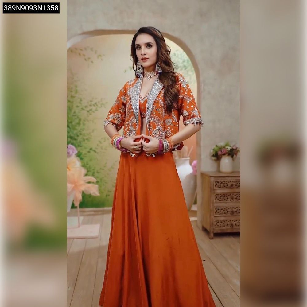 Model wearing orange lehenga choli with embellished jacket, front-facing.