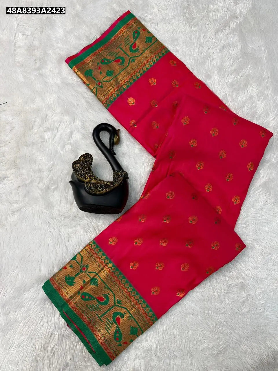 Rani Pink Paithani Silk Saree with green border and copper zari meenakari motifs, flat lay.