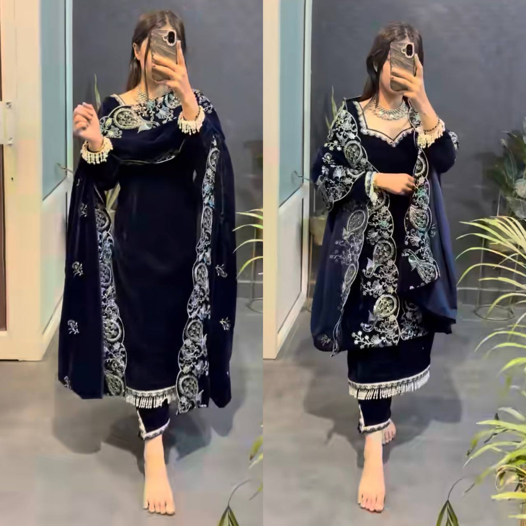 Woman modeling a full-body Midnight Blue Viscose Velvet suit set with intricate silver and green embroidery, holding a phone, full front view.