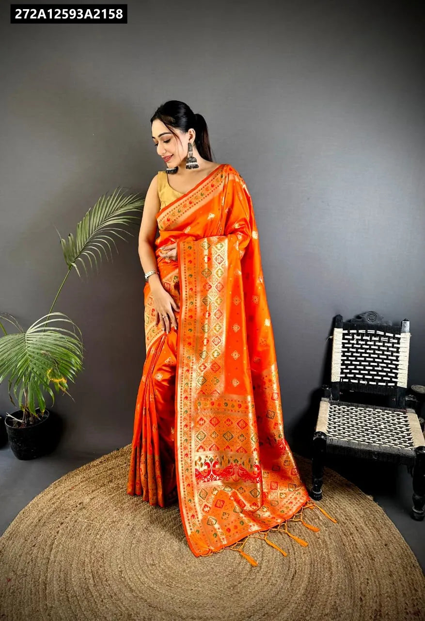 Front 3/4 view of model smiling, wearing an orange Patola Banarasi Lichi Silk Saree with traditional weaving and gold blouse.