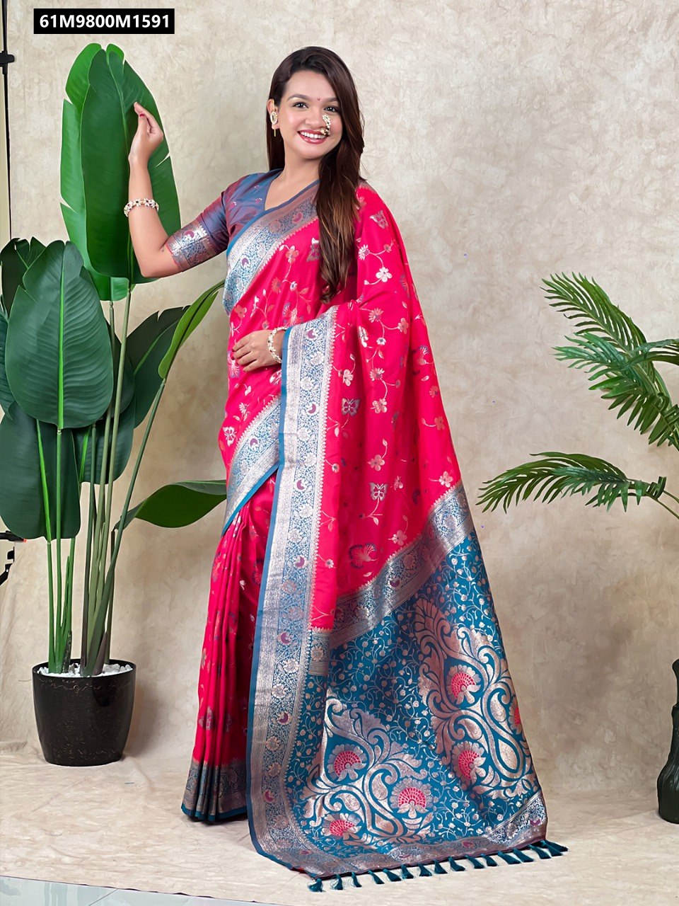 Model wearing a vibrant pink Banarasi soft silk saree with rose gold zari Meenakari jaal and a contrasting blue brocade blouse.