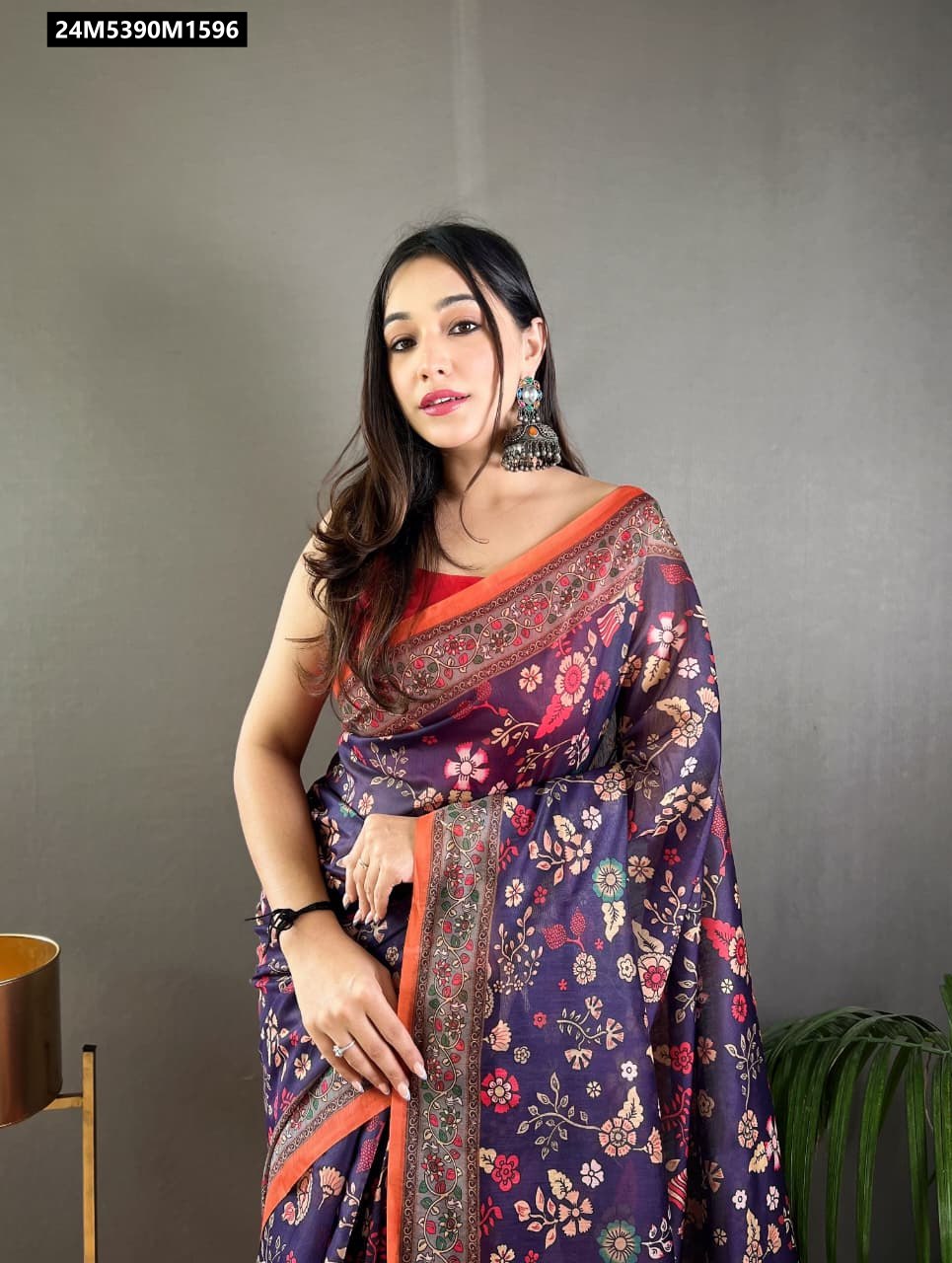 Model wearing a dark purple Kalamkari printed Malai cotton saree with orange border and tassels.