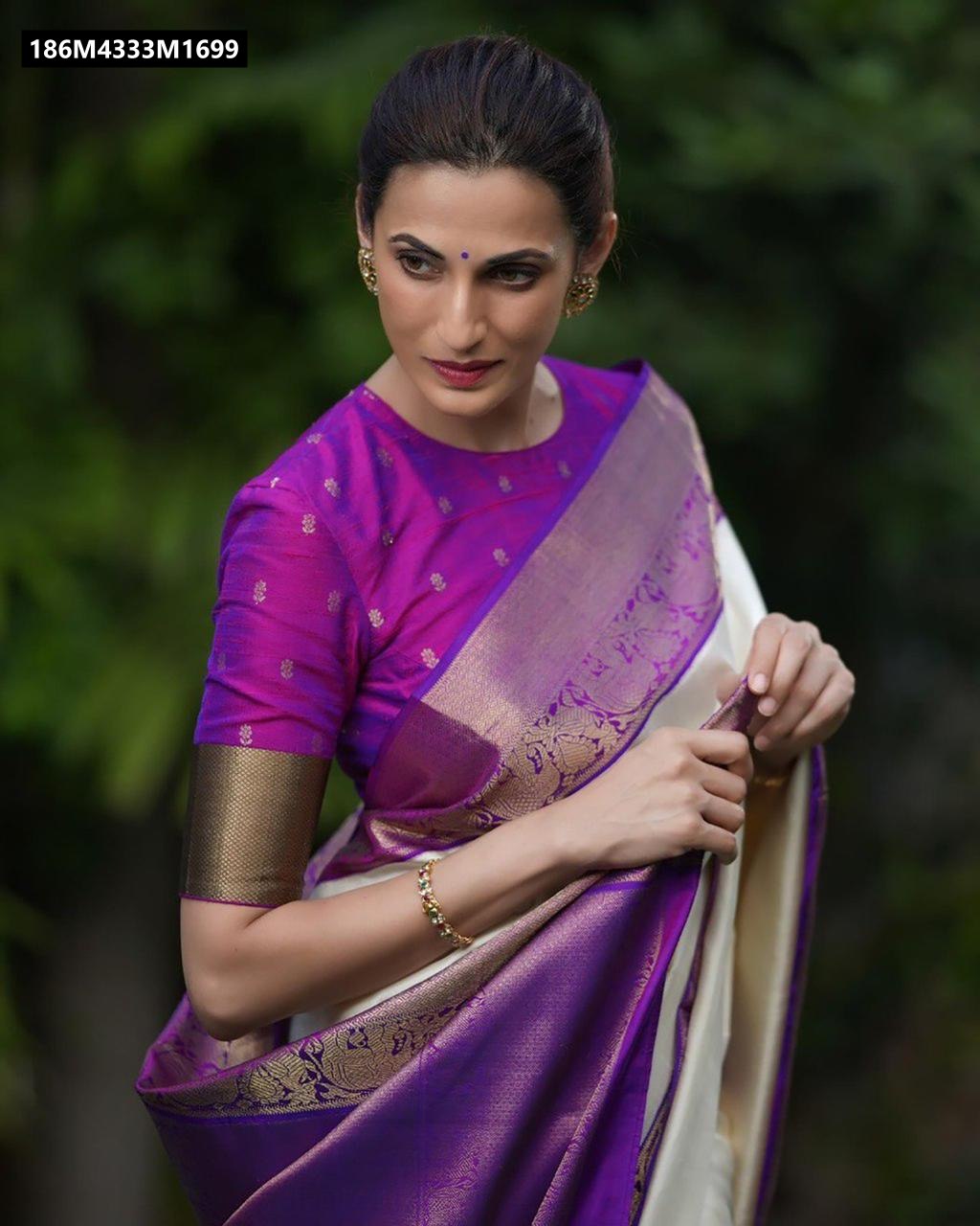 Close-up of a woman in an off-white and purple Banarasi silk saree with gold Zari border, looking away with a thoughtful expression.
