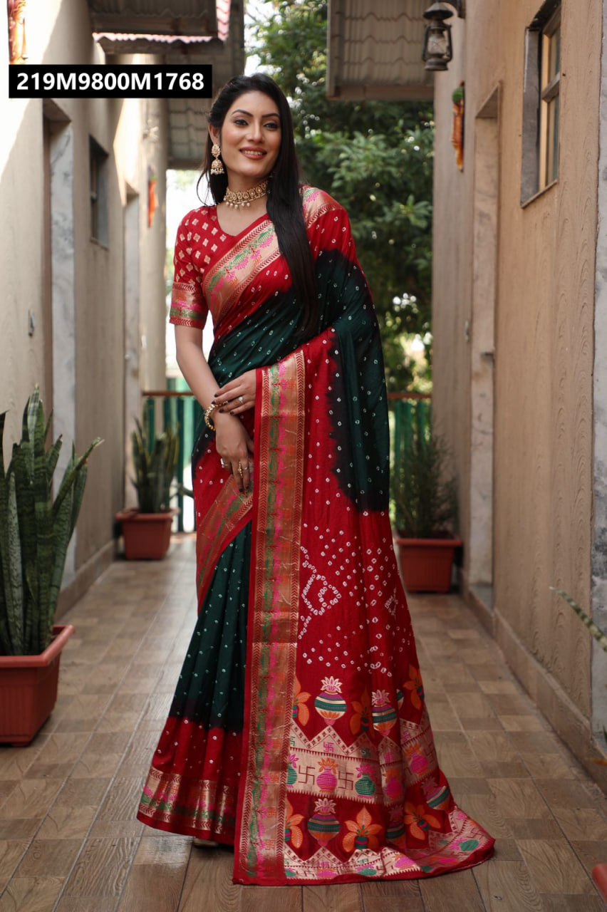Full-length shot of a model elegantly posing in a TRENDBUY Bandhej Silk Saree in deep red and emerald green, with a matching blouse and traditional jewelry, on an outdoor patio.