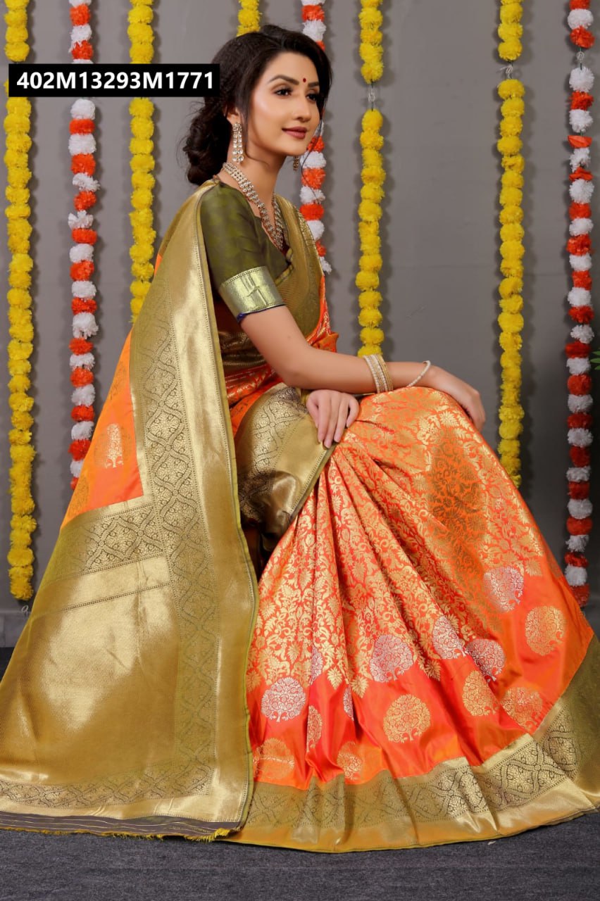A smiling woman gracefully seated, draped in an orange Kanchipuram Pure Silk Saree with rich gold zari borders and pallu, featuring tree motif work, against a festive background of marigold garlands.