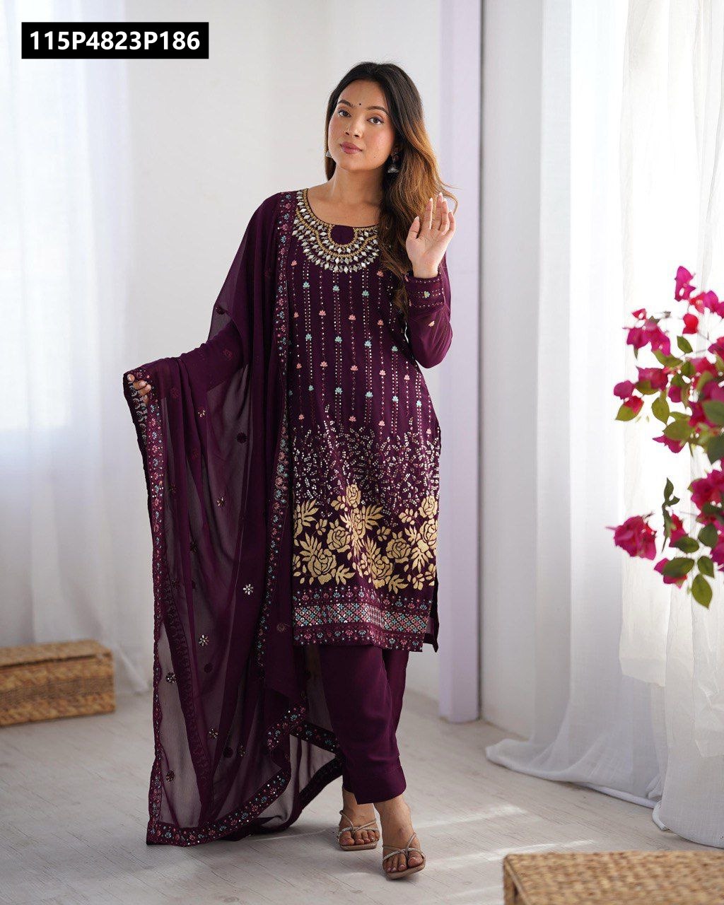 Model wearing a TRENDBUY Wine Faux Georgette Salwar Suit with intricate gold floral embroidery, thread, and real mirror work, showcasing the dupatta.
