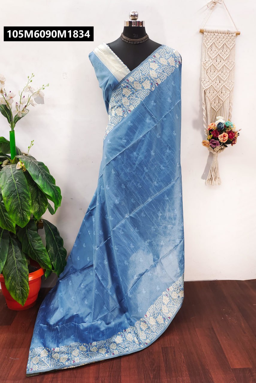Light blue-grey Banglori raw silk saree draped on a mannequin, showcasing a contrast border and pallu with intricate white floral embroidery and small self-weaving buttis.