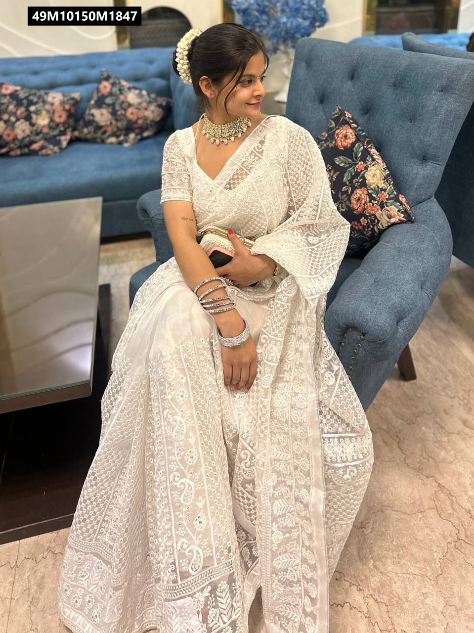 Close-up shot of a woman in the white pure organza saree, highlighting the intricate thread and sequin work on both the saree and the blouse.