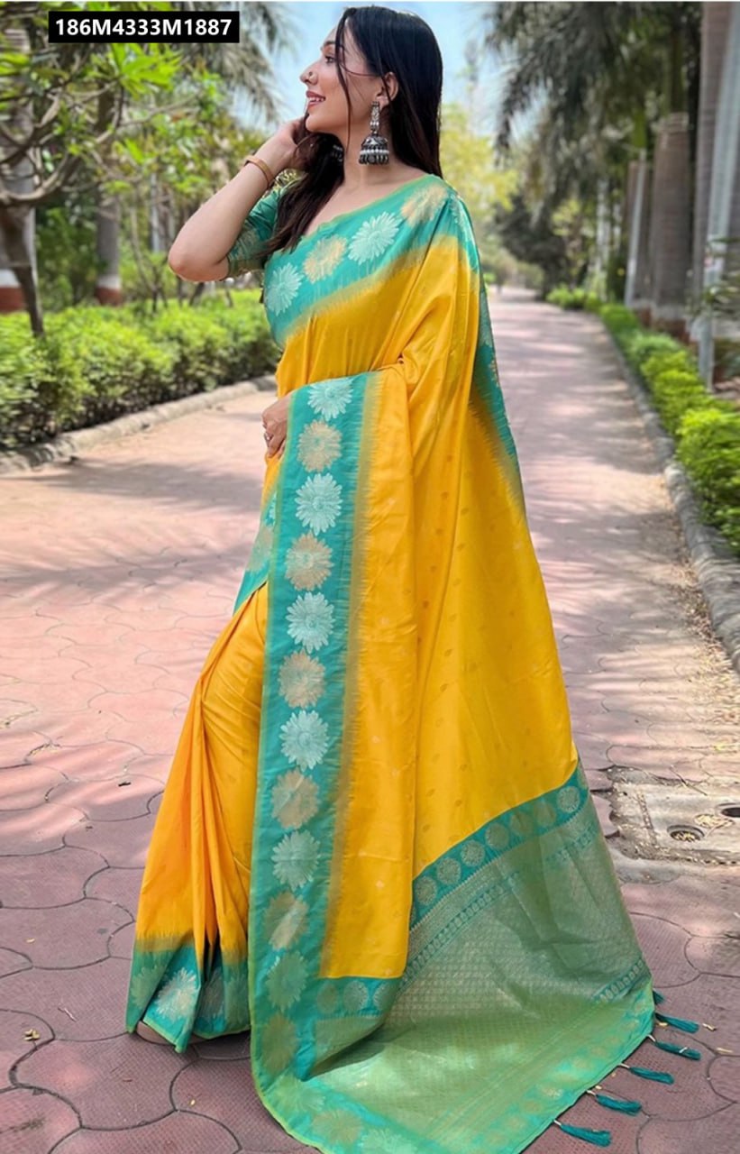 Woman in a bright yellow Banarasi soft silk saree with aqua green Zari border and tassels, side profile.