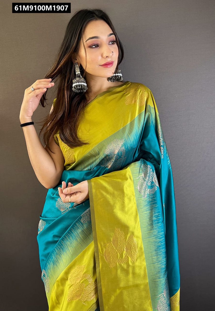 Model shot: Woman gracefully posing in a Teal Blue and Olive Green Soft Silk Saree, showcasing the gradient effect and zari woven pallu and border, wearing jhumka earrings.