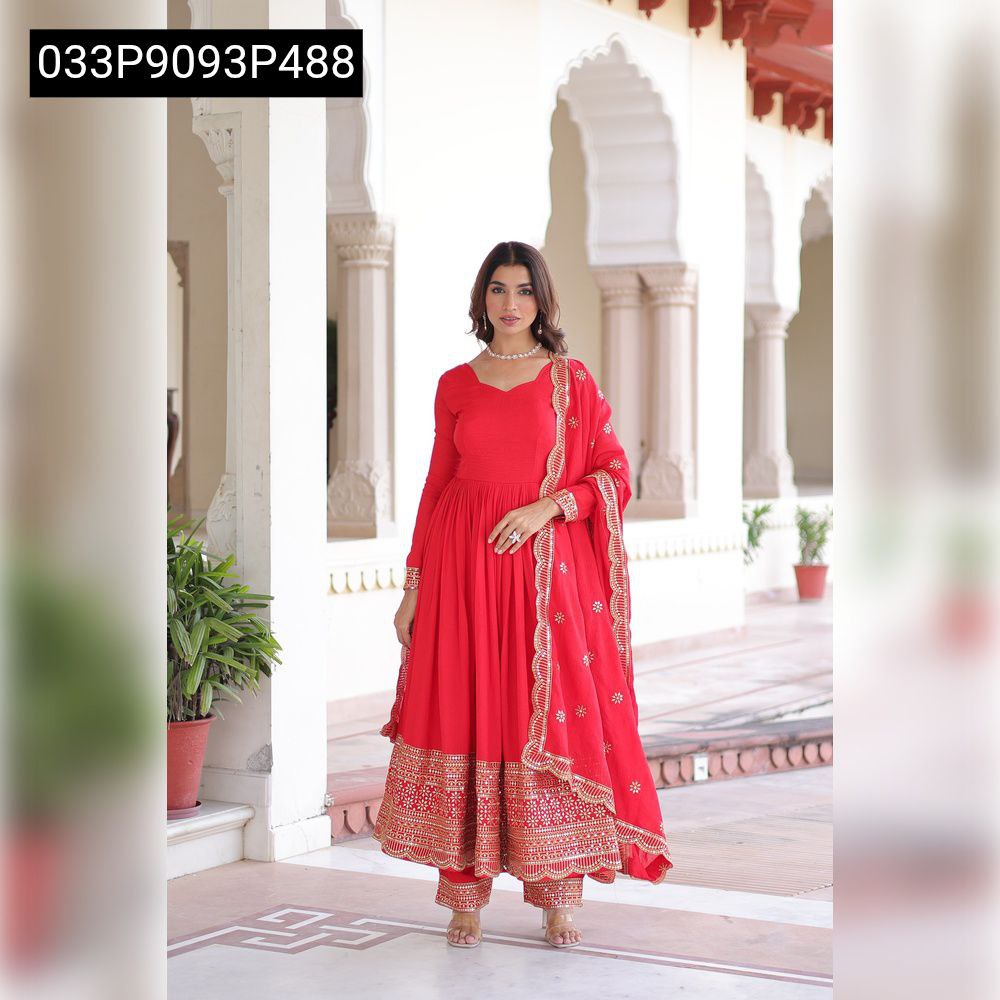 Full frontal shot of model in red Anarkali gown set, standing gracefully against an arched traditional backdrop, showcasing the entire ensemble.